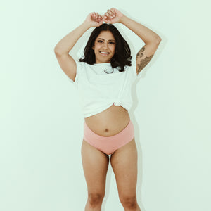Woman posing in clay (pink) cheeky organic cotton underwear, front view.
